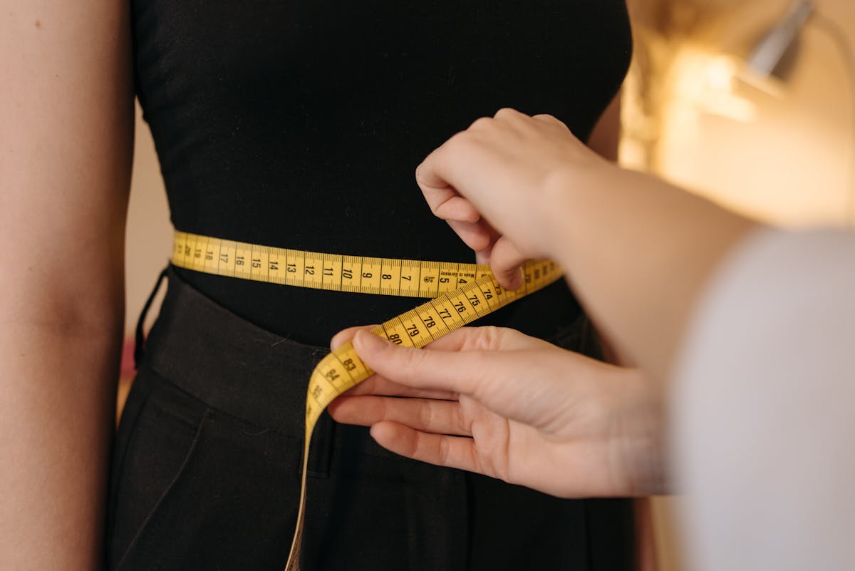 Femme prenant son tour de taille avec un mètre ruban