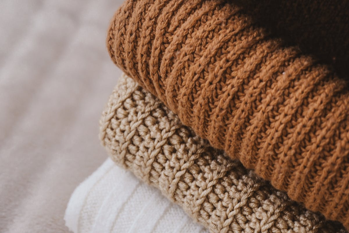 Pulls en laine pliés et empilés dans des tons naturels et doux