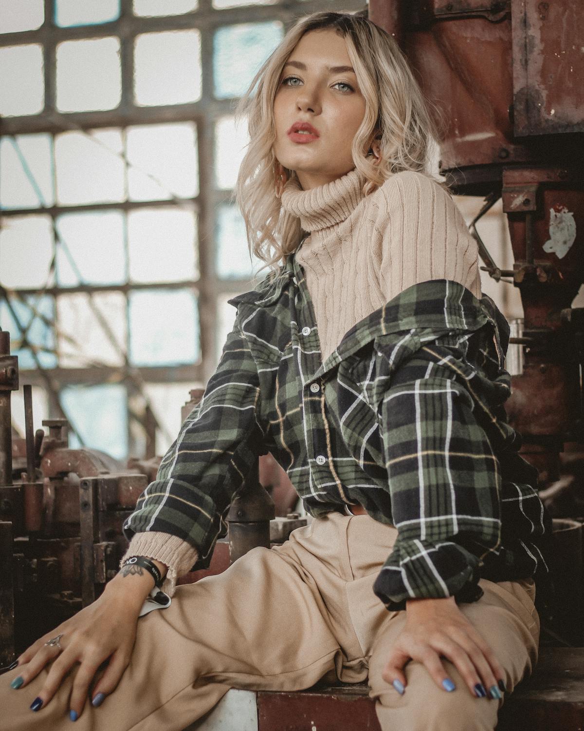 Femme arborant un look grunge avec chemise à carreaux et perfecto
