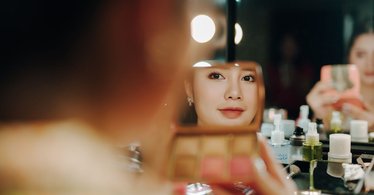 Femme appliquant du blush sur les pommettes pour un teint naturel