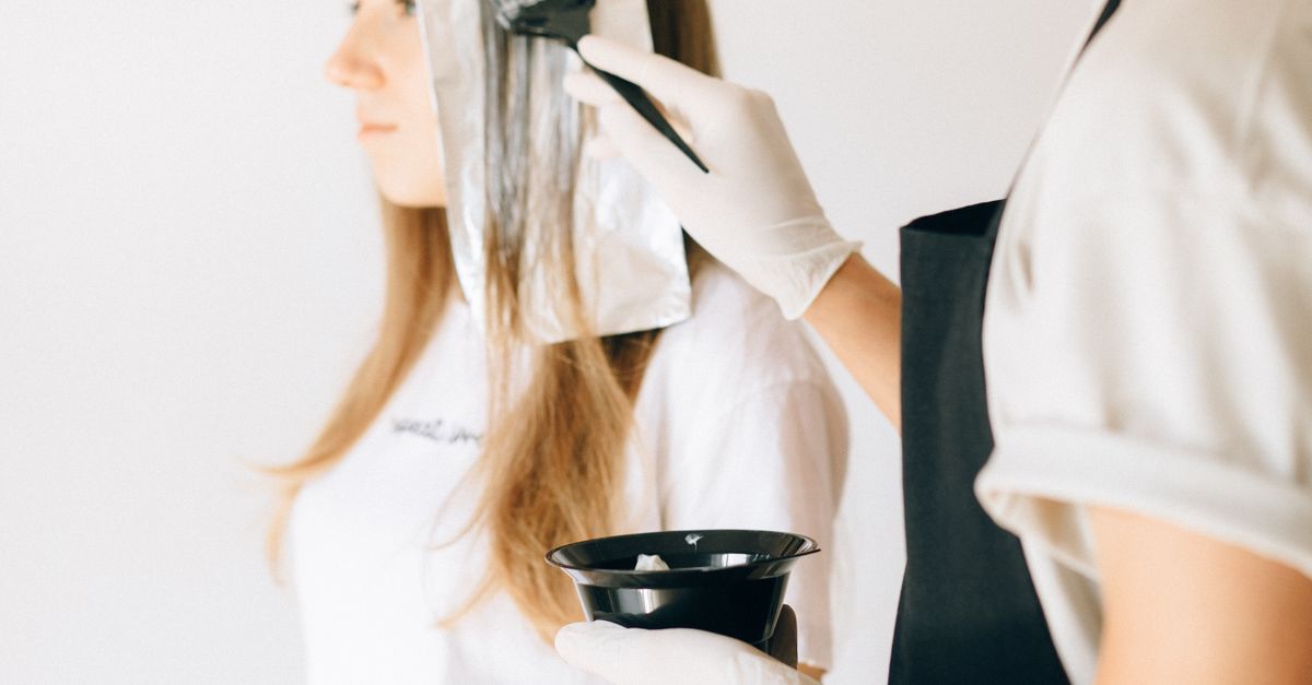 Femme appliquant une coloration capillaire à la maison