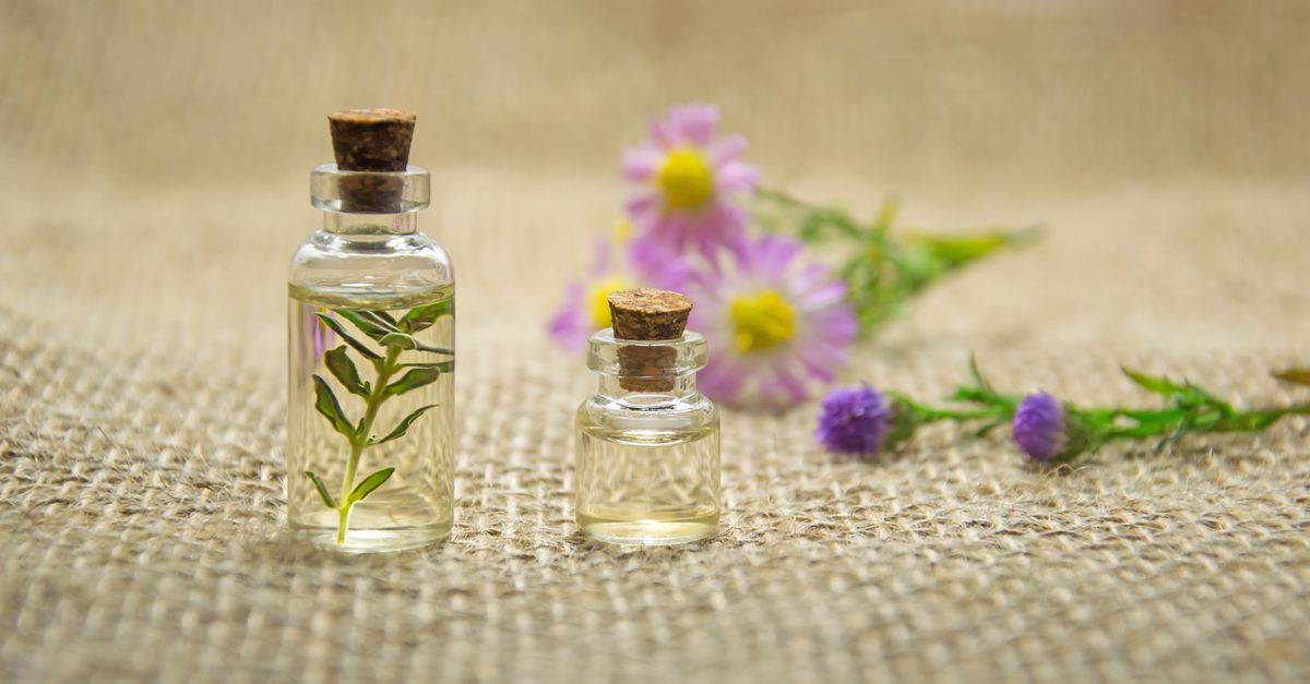 Flacons d'huiles essentielles et plantes aromatiques sur fond naturel