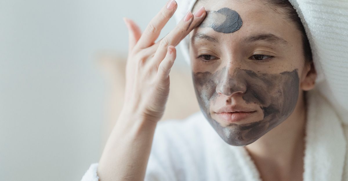 Femme appliquant un masque à l'argile sur le visage