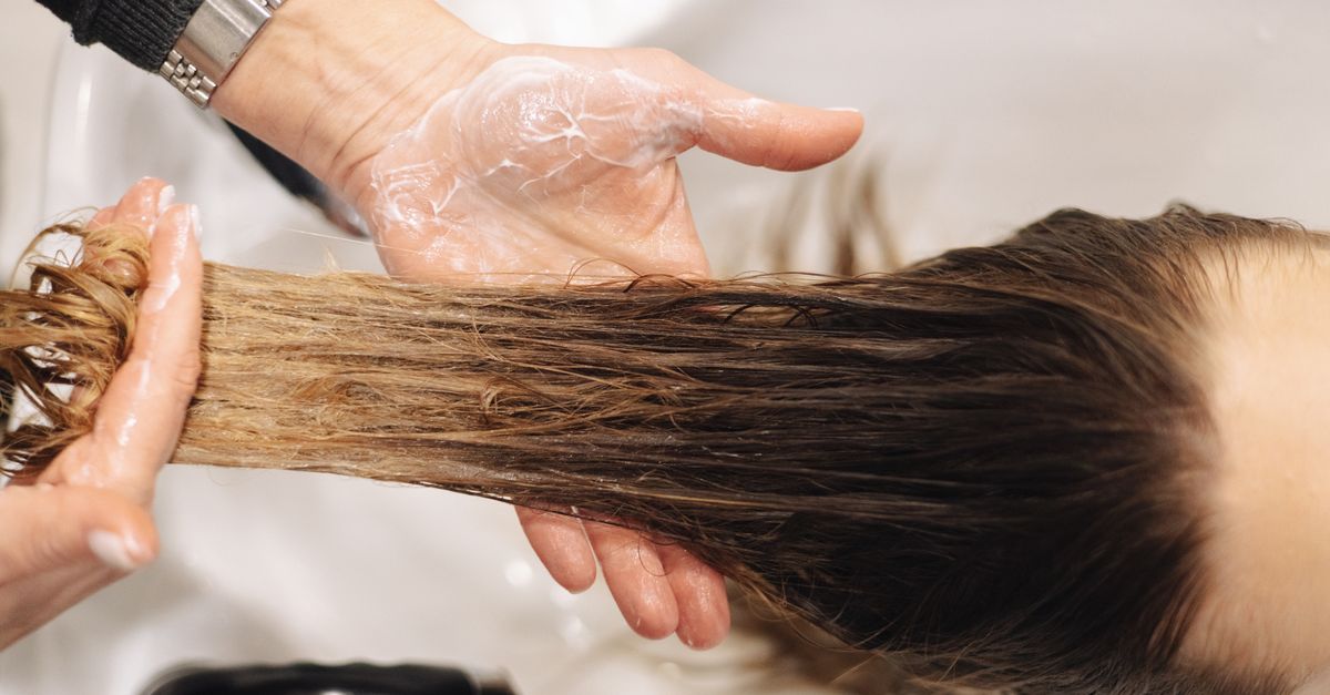 Femme appliquant un soin protéiné sur ses cheveux abimés
