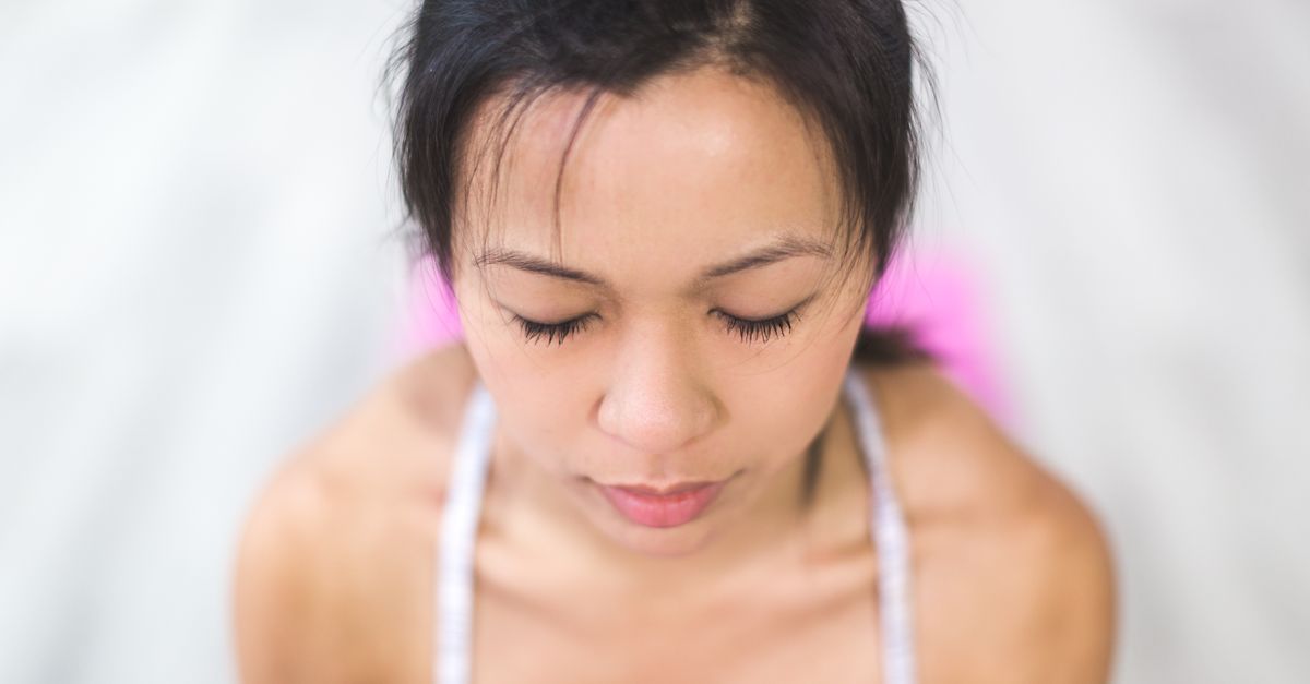 Femme en position de relaxation pratiquant la sophrologie chez elle
